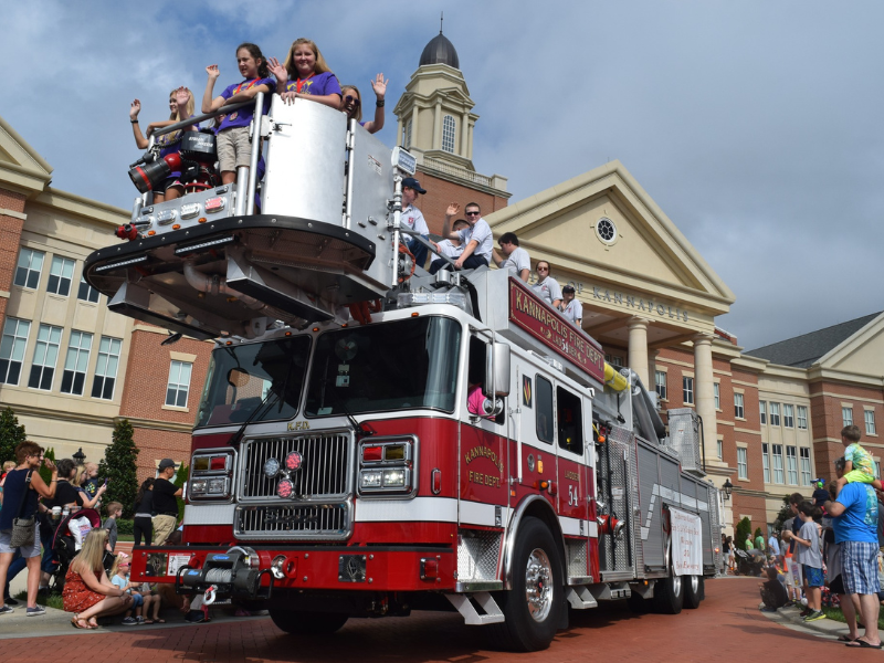 Girls waving from fire truck bucket lift