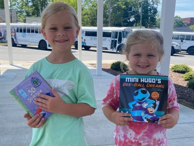 two girls holding up their new books